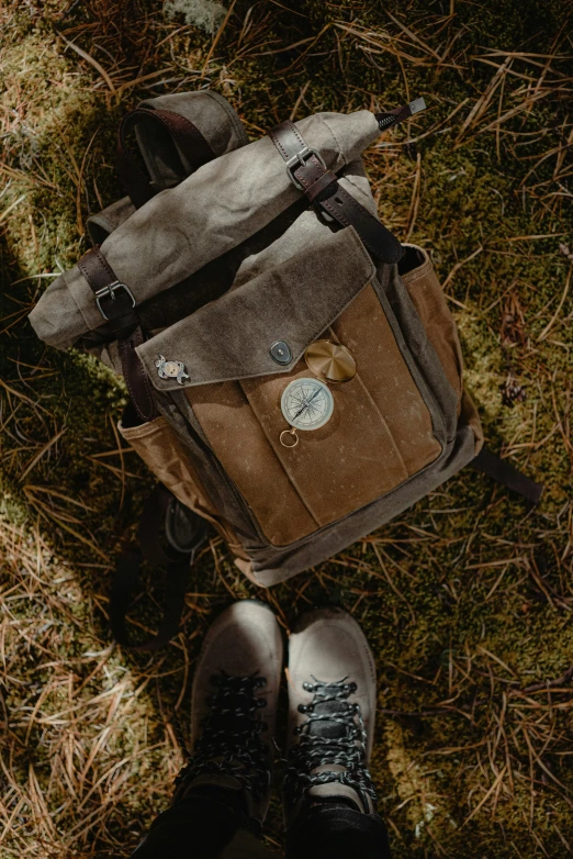 the view from above on someone's shoes next to a brown bag and backpack