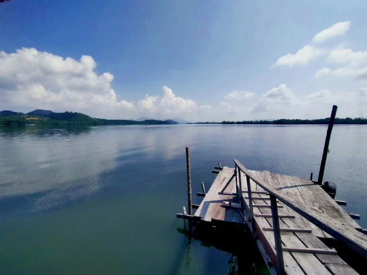 some very pretty blue water with a wooden dock