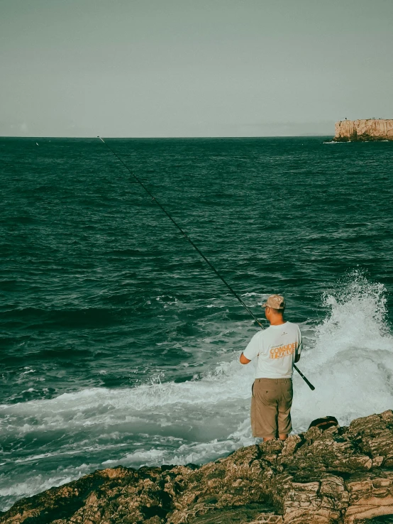 a man fishing on the water, with waves