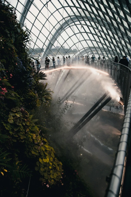 many people walk on a walkway near an archway