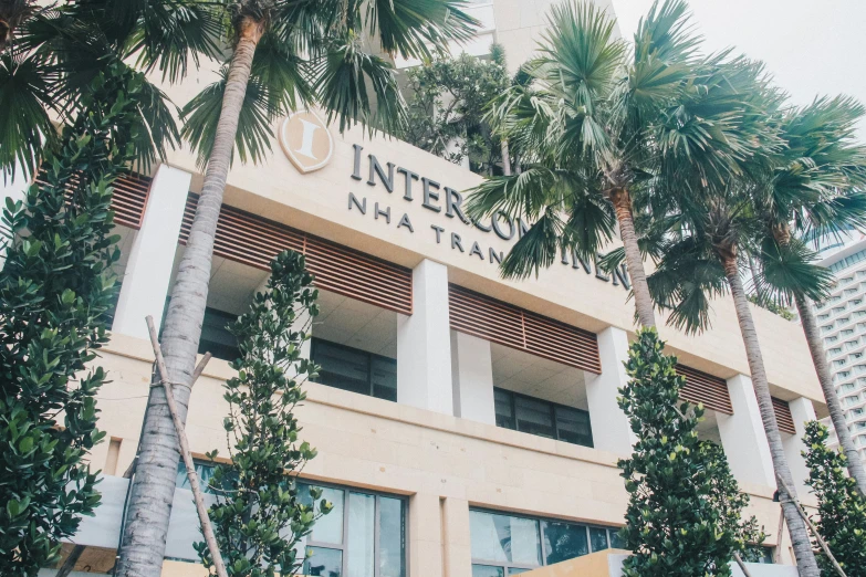 the front entrance to an interco building with three trees in front