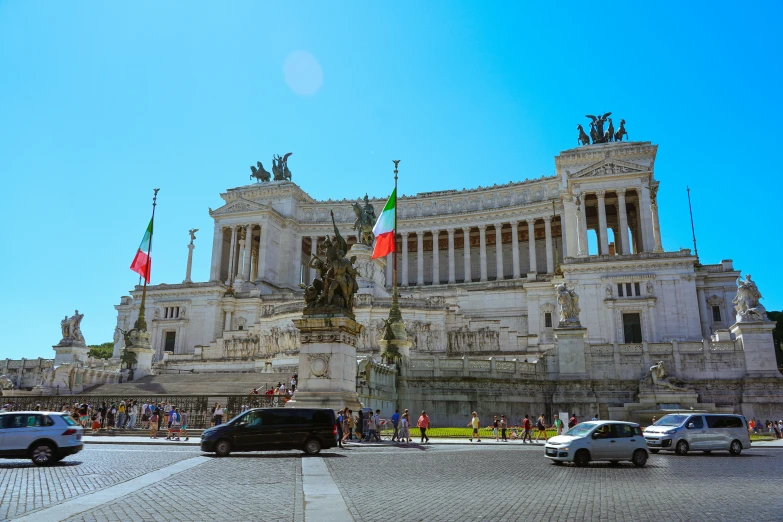 a large building with a statue next to parked cars