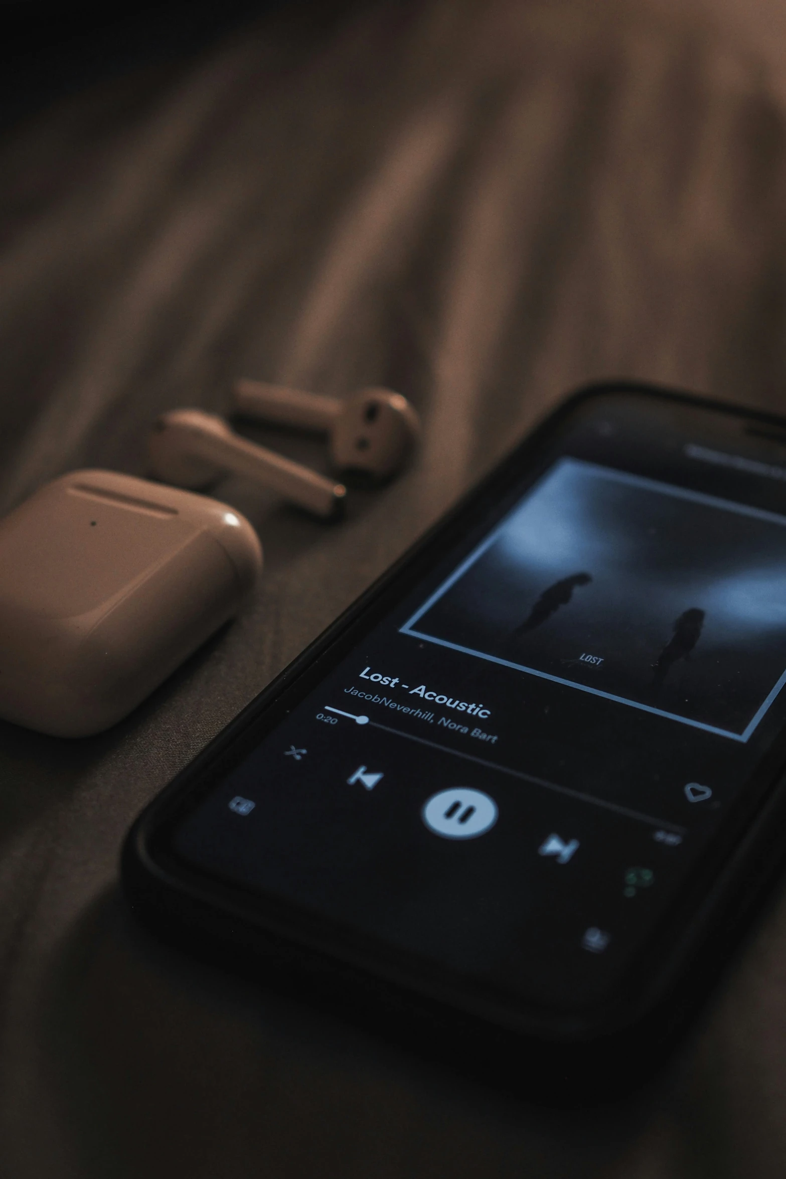 a cell phone sitting on top of a bed next to an mp3 player