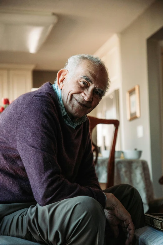 older gentleman smiling as he sits in his chair