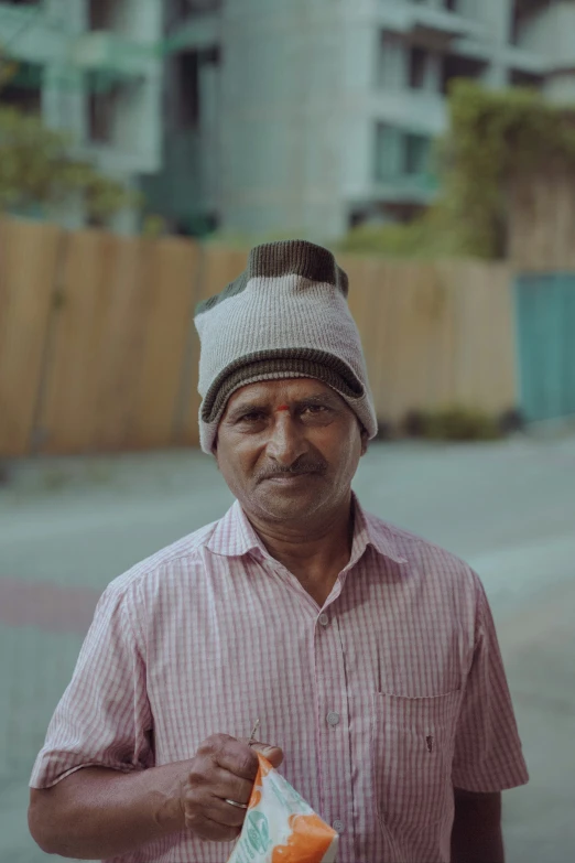 a man holding an empty orange drink in his hand