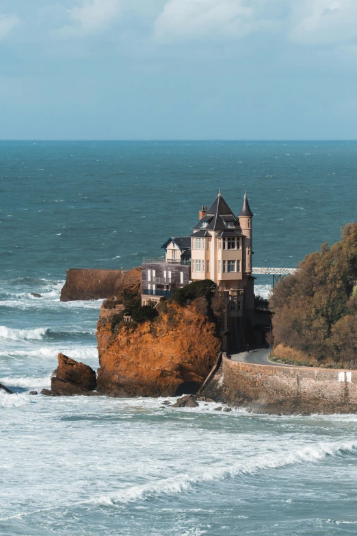 the house is on a small rocky island next to the ocean