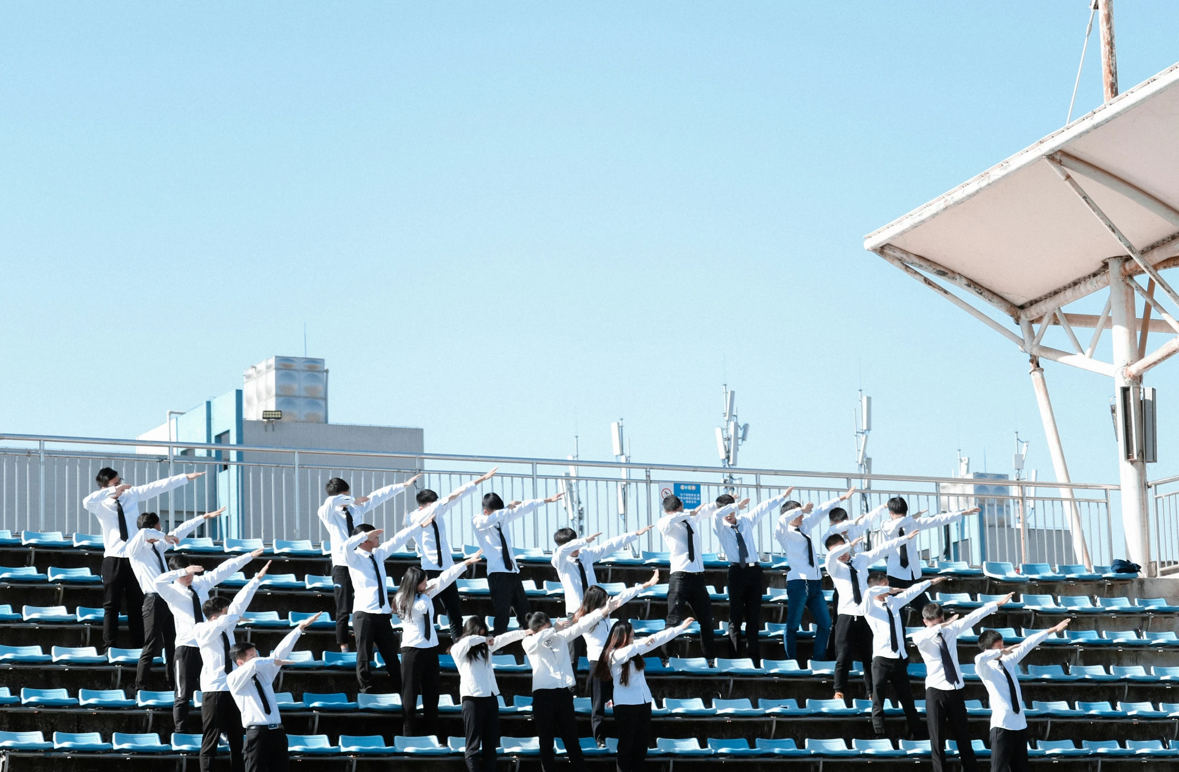 people dancing on bleachers at an outdoor tennis match