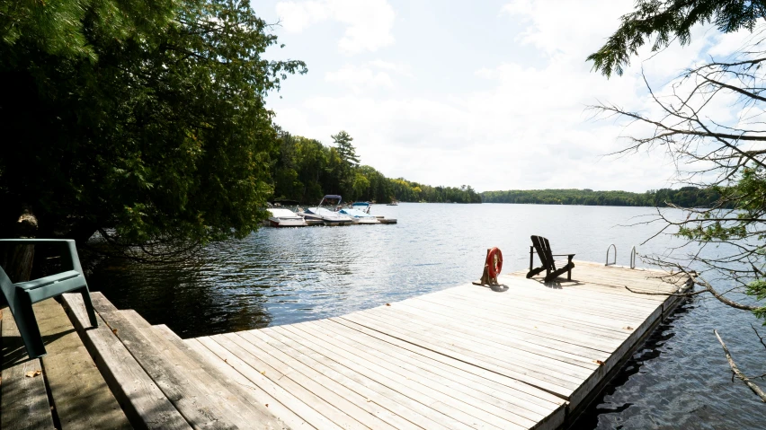 two boats are anchored along the dock as another sits nearby