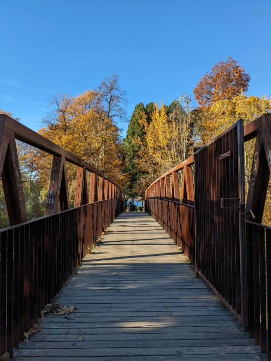 a long, wooden bridge that goes over a lake