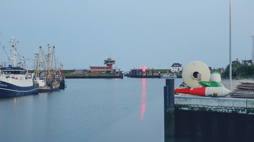 boats in the water with a buoy on a dock next to them