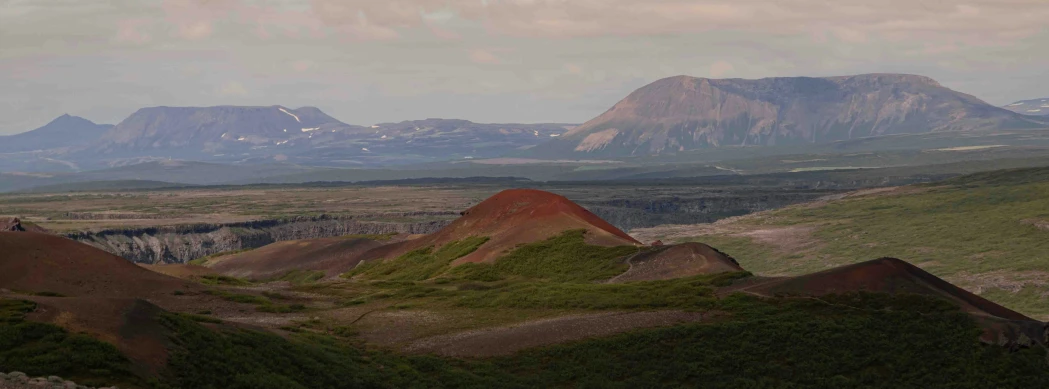 a wide mountain range with several rocks at the bottom and other hills in the distance