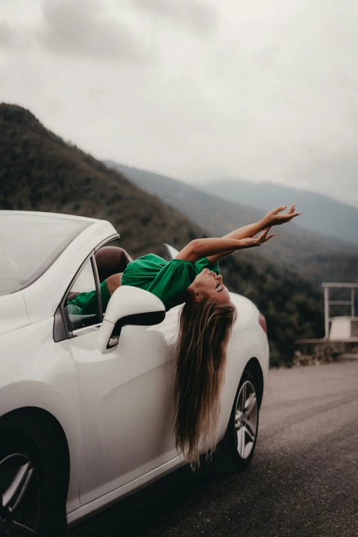 a woman is leaning out the window of a car