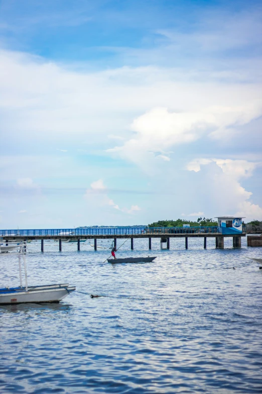 boats floating in the water near an over pass