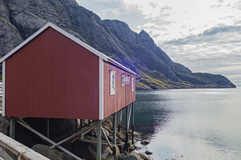 a small boathouse built on stilts near the water