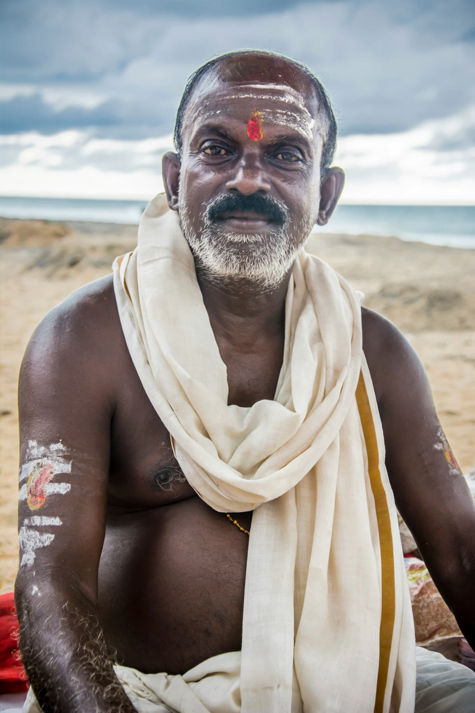 a man with a painted face and body is posing for the camera