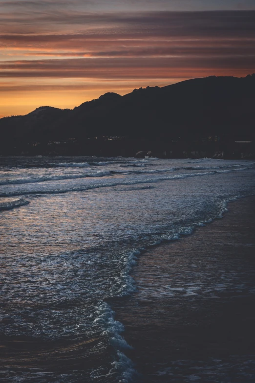 an empty beach has the sun coming down