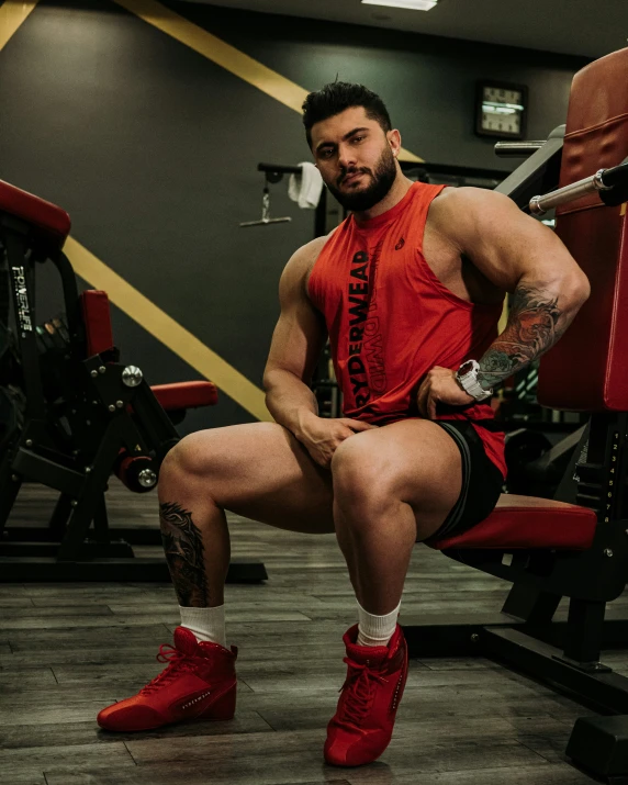 a man sitting on top of a red bench with his arms in the air