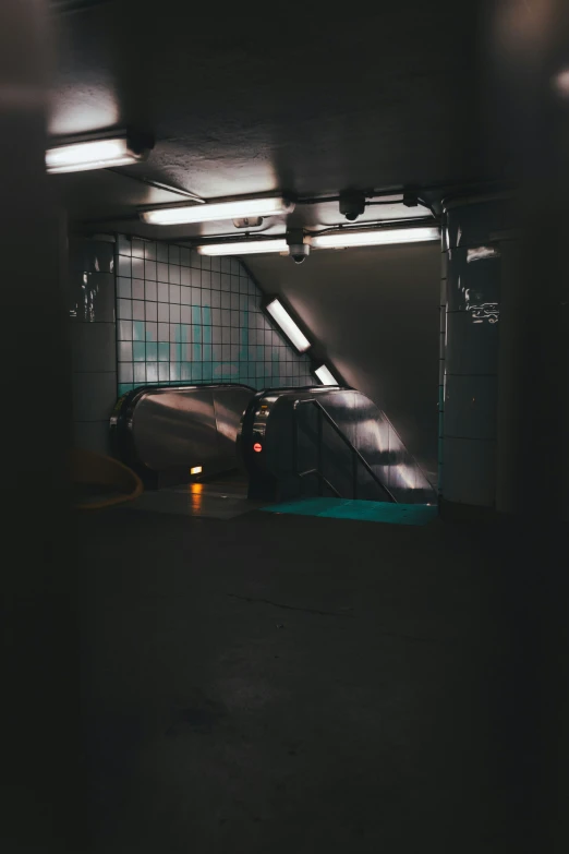 a dark parking garage has cars parked at the bottom