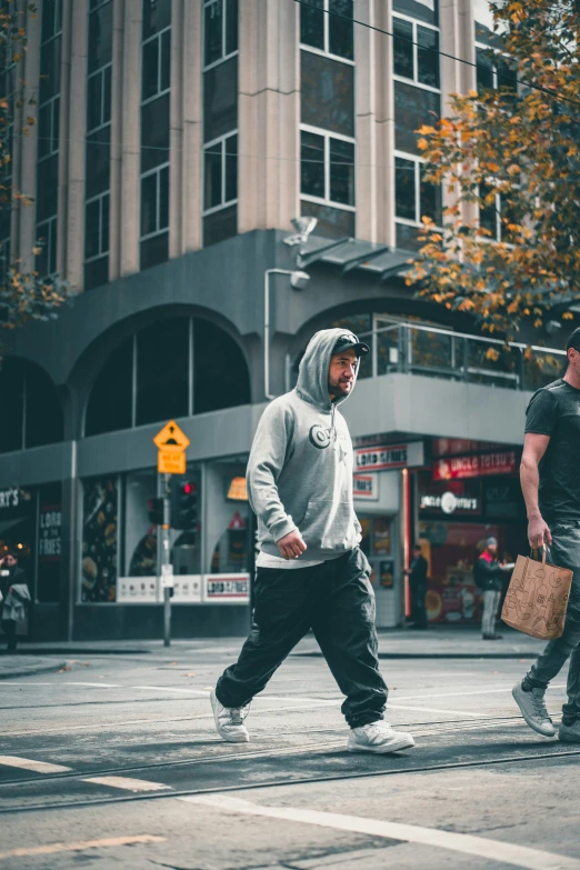 a couple of men walking across a road next to each other