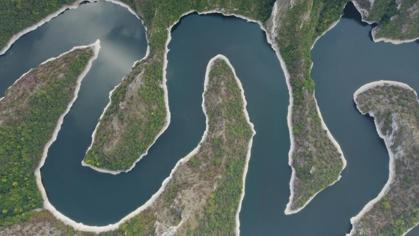 an aerial view of a winding river in the mountains