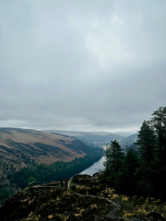 a man hiking on a trail overlooking a mountain valley