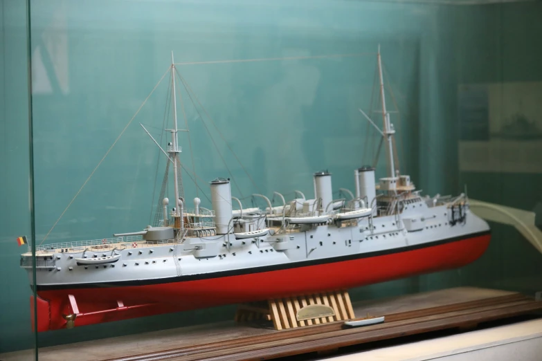 model battleship in glass case on display on wood board