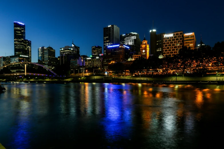 a river next to a city with tall buildings