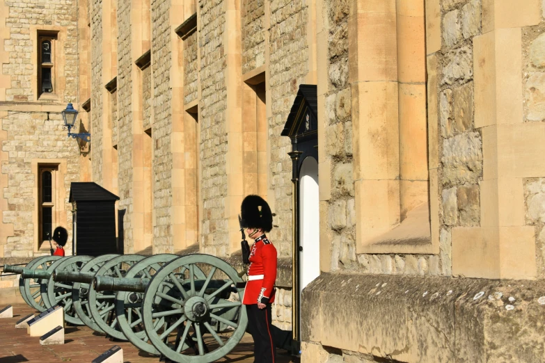 a guard standing near two large cannon wheels