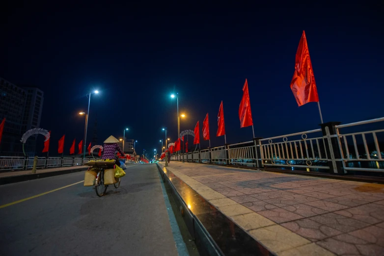 a street filled with flags next to tall buildings