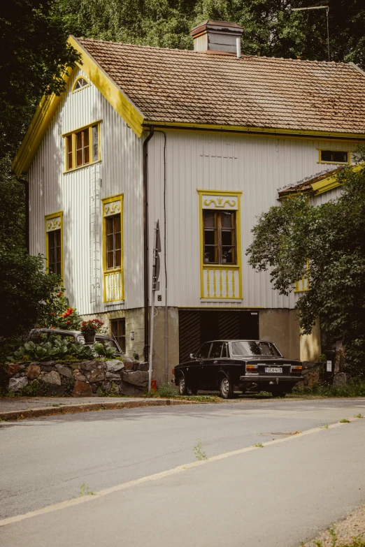 an old building with a car parked in the driveway