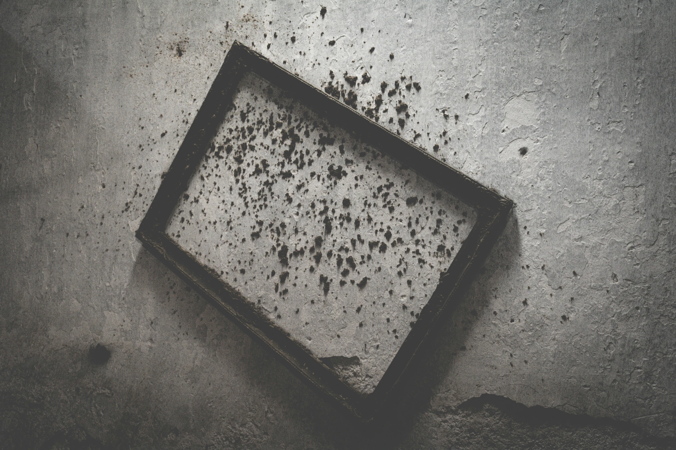 an old square metal object sits on the ground