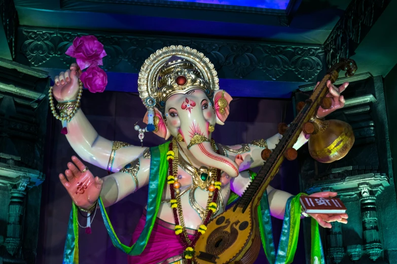 there is a statue of ganesh, with music in his hands