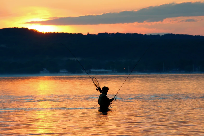 a man in the water who is holding onto a pole