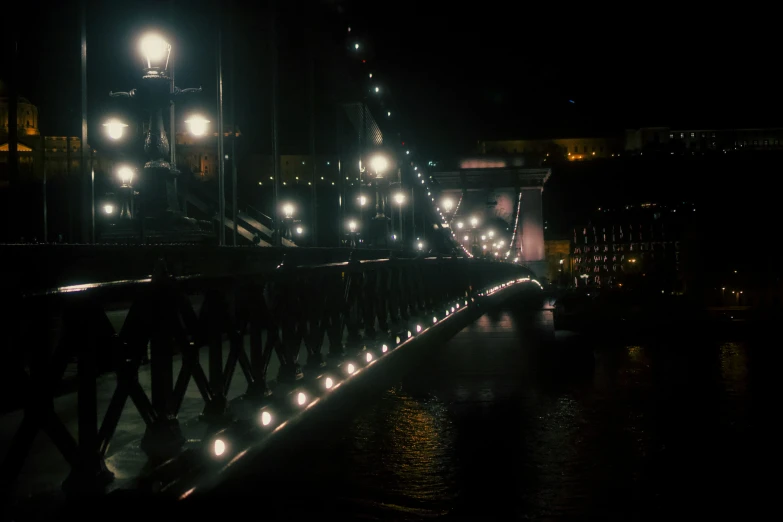 a bridge over a river at night with lights lit up