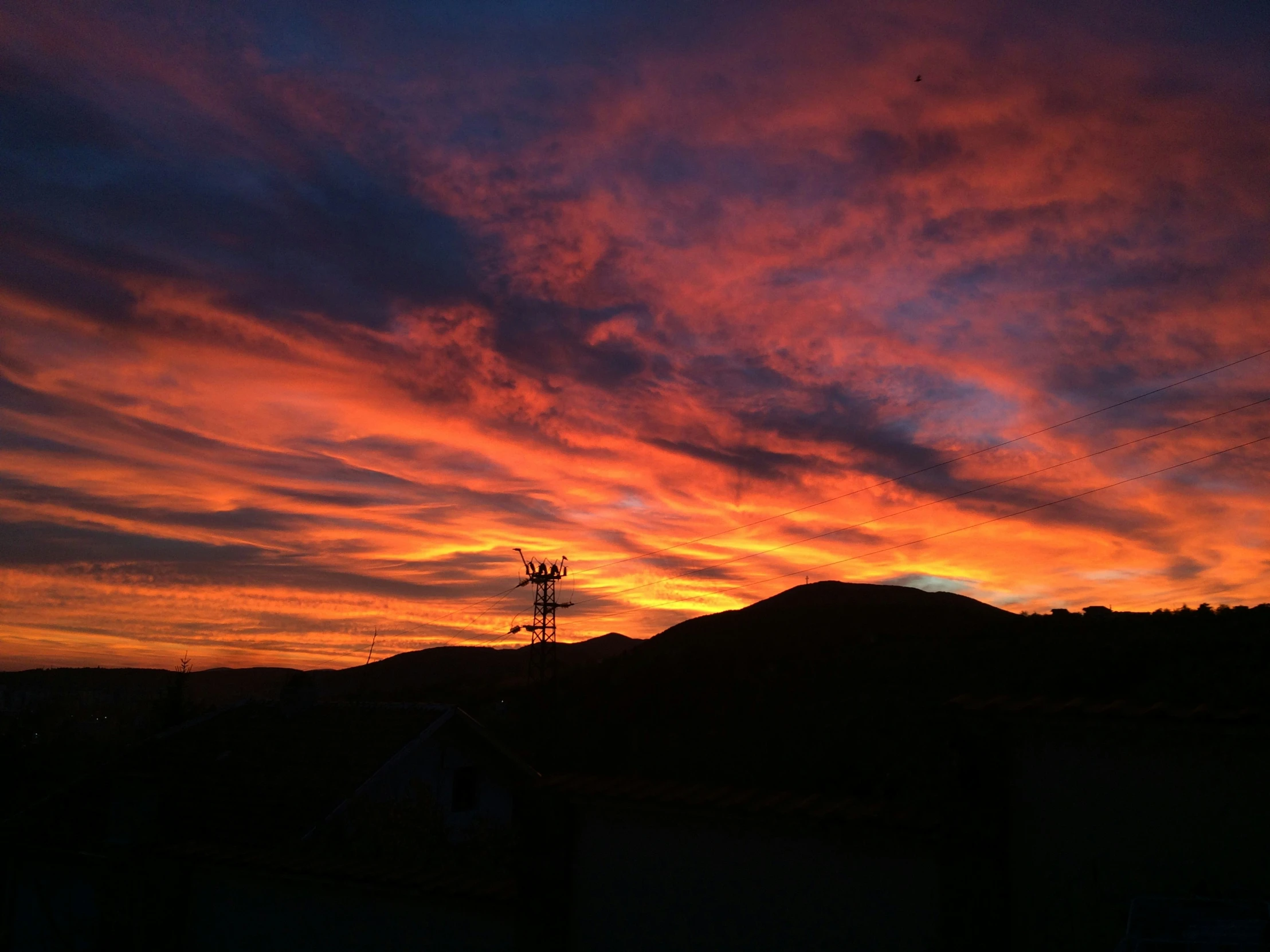 the sun rises over the mountain in the evening sky