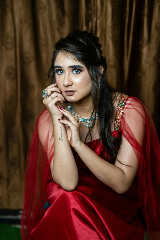 a woman in a red outfit with a hand on her chin