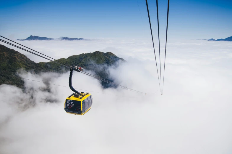 the cable car is suspended above the clouds