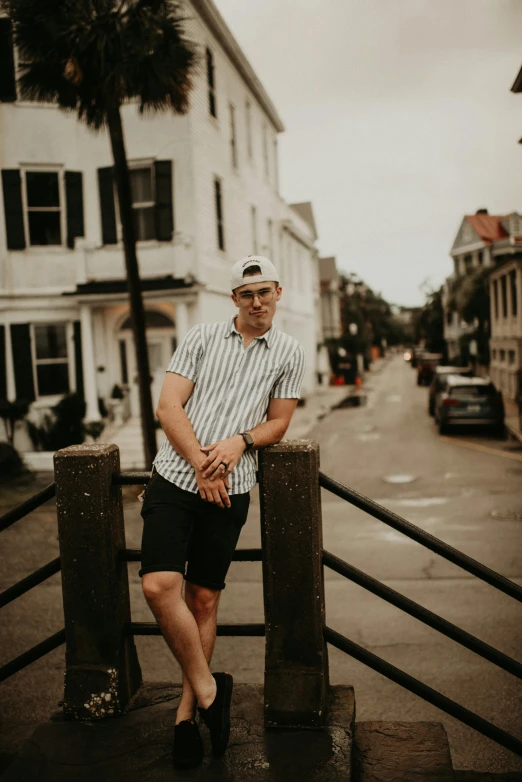 a man posing on some pillars by a building