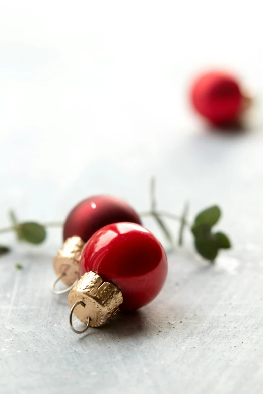 two red glass ornaments in the shape of people