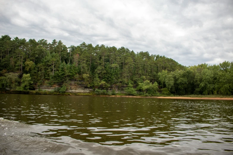 an empty lake surrounded by trees on a cloudy day