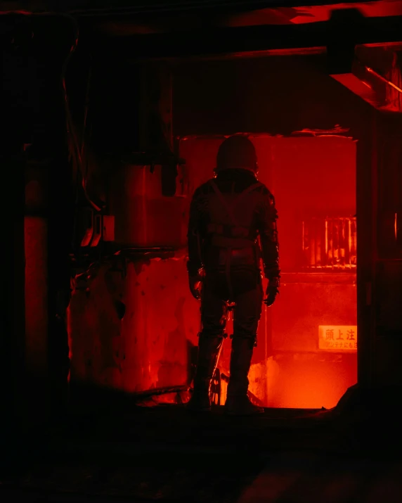 a person in safety gear stands in front of red fire