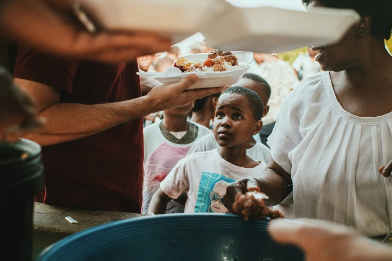 the woman in white is offering food to the children