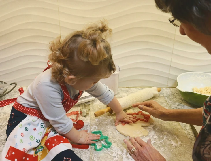 a child plays with a cookie cutter on the kitchen counter