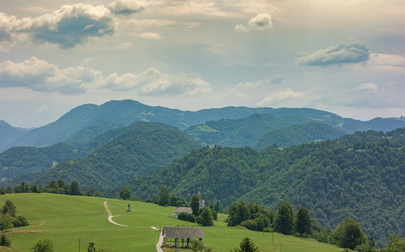 a lush green hill with a long road going through it