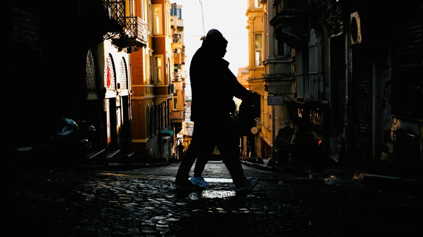 the silhouette of a woman walking in an alley