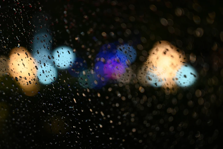 rain and street lights seen through a rain covered window