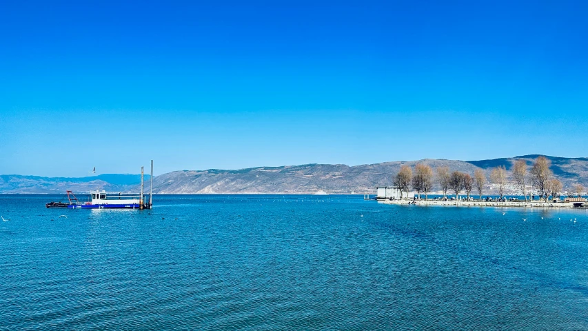 there are boats floating on the calm ocean water