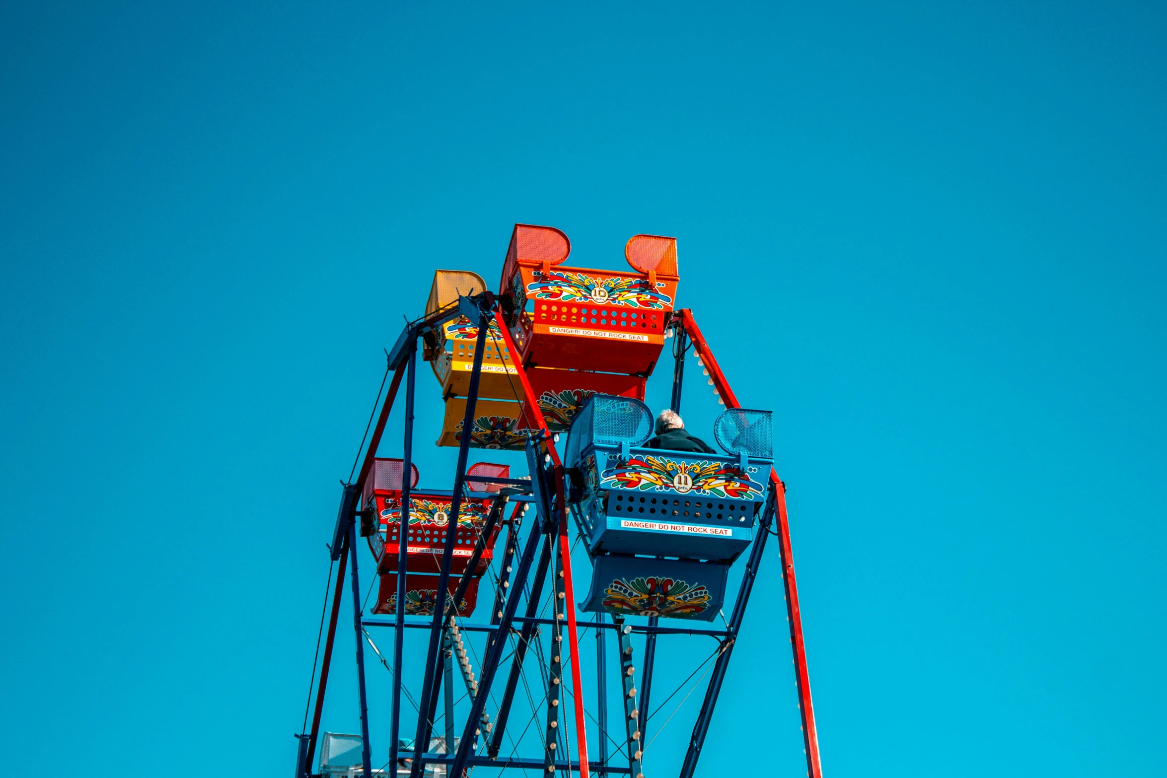 a ferris wheel going through the blue sky