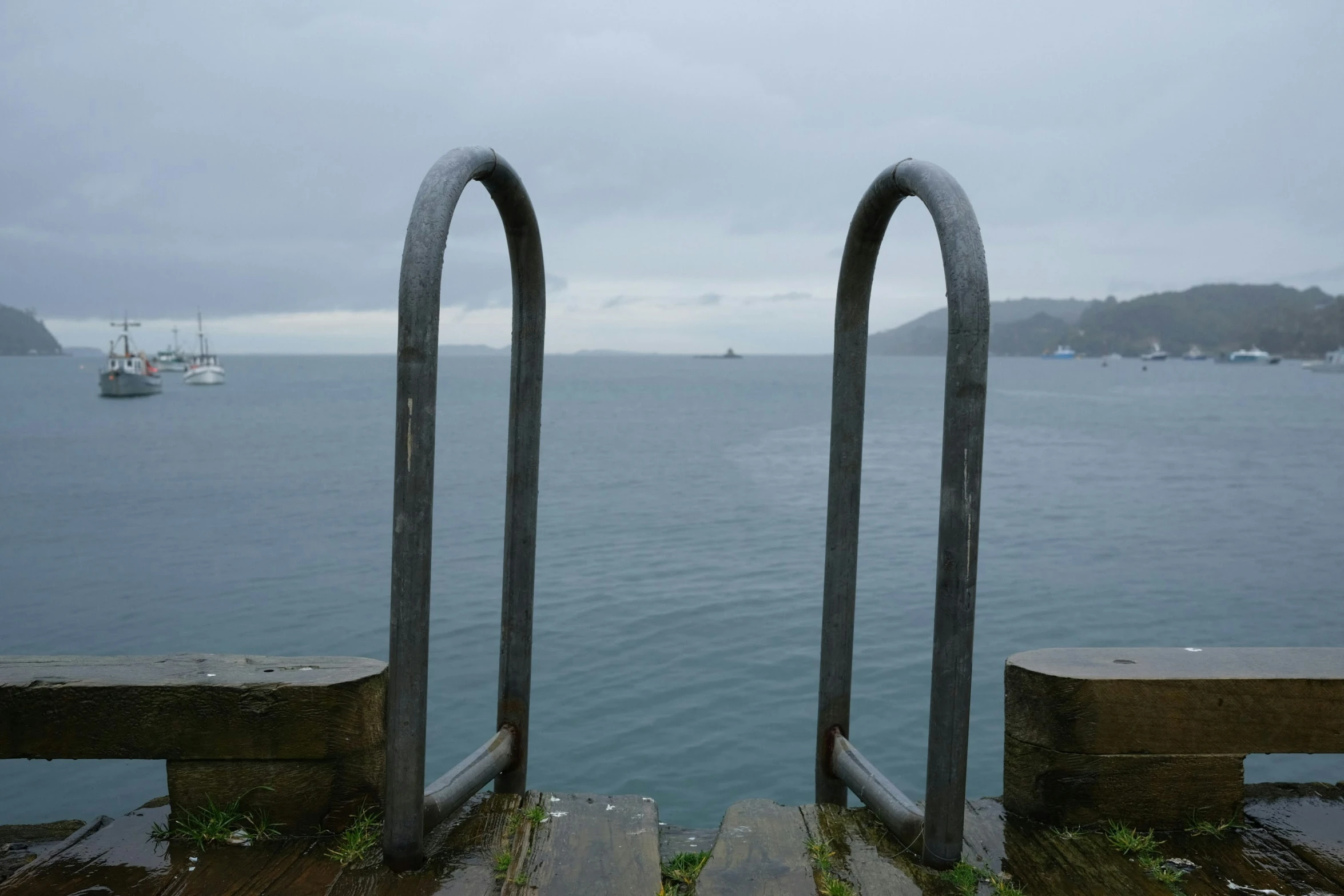 two wooden steps in front of a body of water