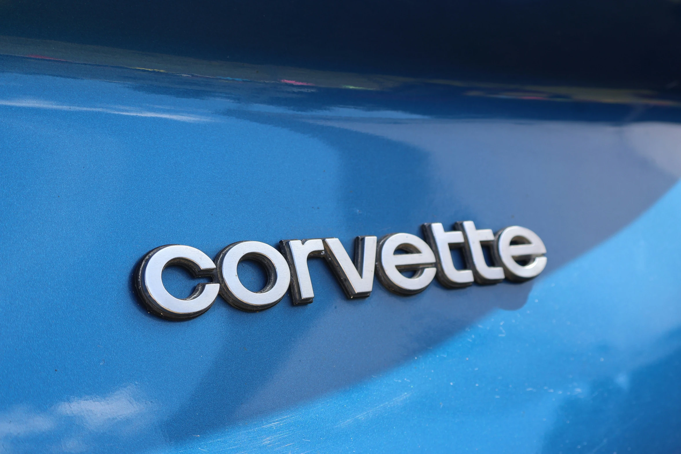 a close up of the word corvette written on the side of a blue vehicle